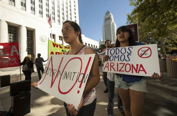 Members of the Coalition for Humane Immigrant Rights of Los Angeles hold a rally in response to the ruling by the U.S. Supreme Court on Arizona's immigration law outside the Federal Court building in Los Angeles Monday, June 25, 2012. California’s TRUST Act focuses on community safety and fiscal responsibility without straying into immigration policy. (AP/Damian Dovarganes)