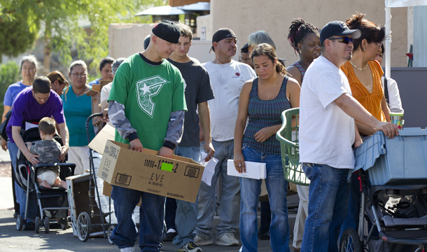 People stand in line waiting to fill boxes with food at a Las Vegas food pantry. The Community Services Block Grant supports many community-based activities helping people transition out of poverty, including access to food pantries for families who have lost their jobs. (AP/Julie Jacobson)