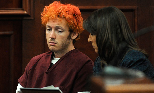 Public Defender Tamara Brady, right, shows James E. Holmes documents as he appears in Arapahoe County District Court in Centennial, Colorado. Holmes is accused of killing 12 and wounding 58 in a shooting rampage in a movie theater on July 20 in Aurora, Colorado.<br /> (AP/RJ Sangosti)