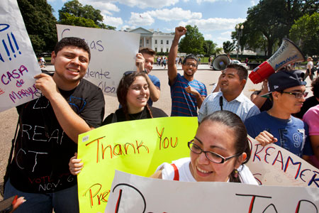 Supporters of President Barack Obama's announcement that the U.S. government will stop deporting and begin granting work permits to younger illegal immigrants who came to the United States as children and have since led law-abiding lives gather outside the White House on June 15.
