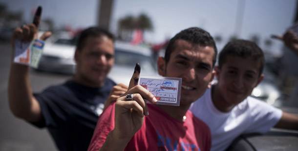 Libyan men hold their elections ID cards while celebrating election day in Tripoli, Libya, on July 7, 2012. The new government must focus on keeping the country safe.
<br /> (AP/Manu Brabo)