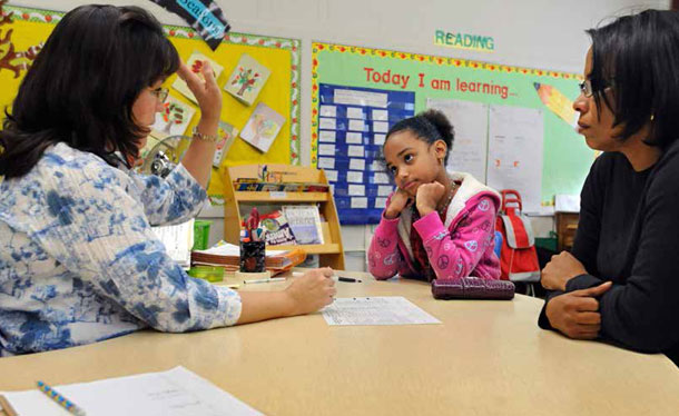 Bilingual teacher Maritza Roman, left, meets with parent Andrea Rosa, right, for a parent-teacher conference for Rosa's daughter Angelica Vilorio, center, at Windham Center School in Windham, Connecticut.
<br /> (AP/Jessica Hill)