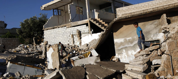 Syrian boys play in the rubble of house that was destroyed during a military operation by the Syrian pro-Assad army in the town of Taftanaz, east of Idleb, Syria. (AP/Khalil Hamra)