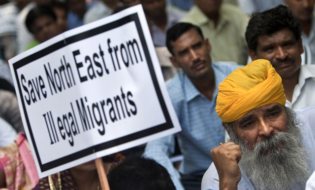 An Indian supporter holds a placard during a protest against what they say is illegal migration of Muslims from Bangladesh to the northeastern Indian state of Assam. The conflict in the state could get worse as the effects of climate change become more drastic. (AP/Tsering Topgyal)
