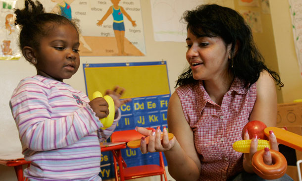 Home-based child care worker Jennie Rivera plays with Jaylin, 2. Child care is an extremely important issue that many working families need help with in order to achieve greater economic productivity and prosperity now and in the future.<br /> (AP/Mary Altaffer)