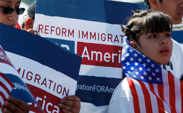Una mujer no identificada sostiene una bandera estadounidense mientras asistía a una manifestación para impulsar a los legisladores a considerar la reforma de las políticas de inmigración en parque Confluence en Denver el Domingo, Marzo 21, 2010. (AP/David Zalubowski)