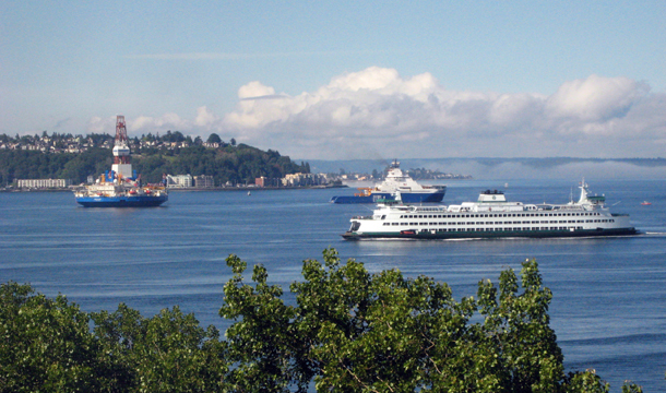 Ships bringing oil drilling equipment to Alaska, left, pass through Seattle's Elliott Bay as a Washington State Ferry passes on its way into Seattle, Wednesday, June 27, 2012. (AP/Donna Gordon Blankinship)