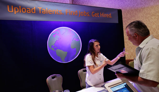 Una reclutadora TalentEarth, a la izquierda, habla con un hombre desempleado, a la derecha, en una feria de trabajo en San José, California, en julio.  TalentEarth es una agencia de empleo. (AP/Paul Sakuma)