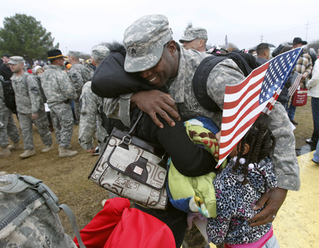 Sgt. Howard Acoff hugs his family as U.S. Army 1st Cavalry 3rd Brigade soldiers return home from deployment in Iraq at Fort Hood, Texas, Saturday, December 24, 2011. (AP/Erich Schlegel)