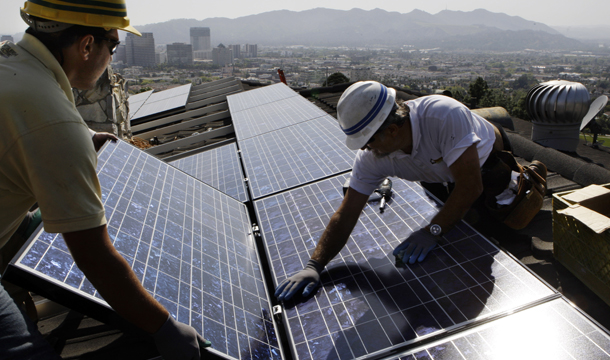 Two employees of California Green Design install solar panels on the roof of a home in Glendale, California. The 