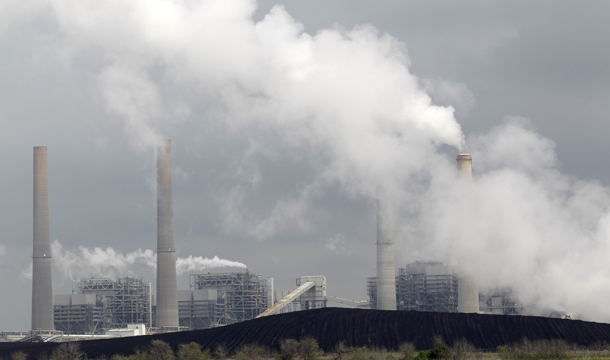 Exhaust rises from smokestacks in front of piles of coal at NRG Energy's W.A. Parish Electric Generating Station in Thompsons, Texas. (AP/David J. Phillip)