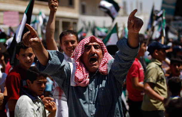 A Syrian man chants slogans during an anti-Bashar al-Assad protest after Friday prayers on the outskirts of Idlib, Syria. (AP/ Khalil Hamra)