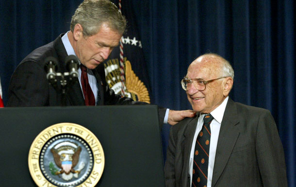 President George W. Bush shows economist Milton Friedman to the podium after making remarks honoring him during a ceremony in Washington in 2002.<br /> (AP/Doug Mills)