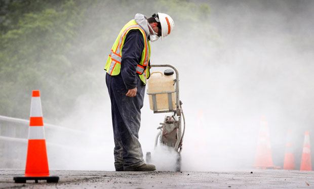 Maine Department of Transportation worker Alan Ladd creates a dust cloud while cutting concrete in Richmond, Maine. An infrastructure bank would organize spending on infrastructure and promote investment in infrastructure projects. (AP/Robert F. Bukaty)