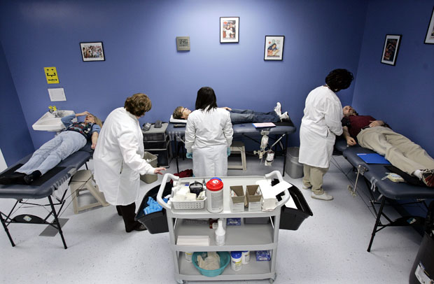 People rest on tables as they give blood for the Red Cross in Princeton, New Jersey. The lifetime deferral policy for MSM blood donors has been called into question for years because of its lack of a scientific basis and its failure to reflect the current technologies used by blood donation centers across the country. (AP/Mel Evans)