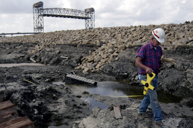 Wesley Pritchard walks beside the rebuilt levee along the Industrial Canal in the lower Ninth Ward of New Orleans, Saturday, October 1, 2005. The levee was breached after both Hurricanes Katrina and Rita flooded the adjacent neighborhood. (AP/Charlie Riedel)