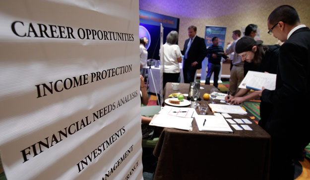 People looking for work talk at a Primerica job booth at a job fair in San Jose, California. The economy continued to make gains in September but remains sluggish in some areas. (AP/Paul Sakuma)