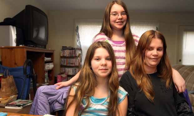Chrissy Fairbanks poses with her daughters Angela, 11, left, and Alexus, 12, at their home, in Keene, New Hampshire, Tuesday, February 7, 2012. Legally blind since she was 9, Chrissy Fairbanks has received Supplemental Security Income due to her disability. (AP/Jim Cole)