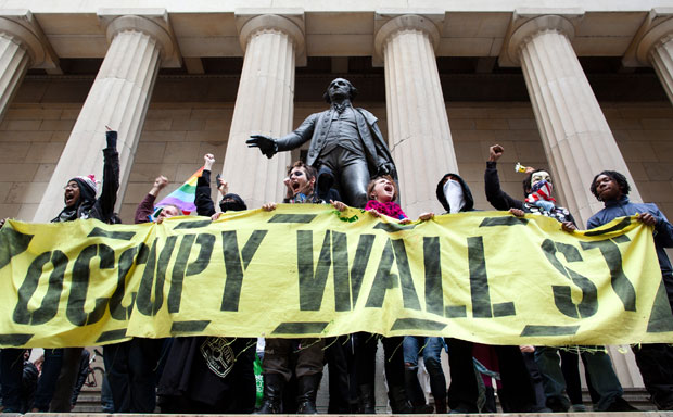 Occupy Wall Street demonstrators stand and cheer in front of the George Washington statue on Wall Street. (AP/John Minchillo)