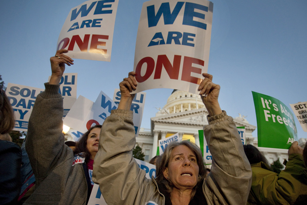 Karen Wallace, right, and Meryleigh Brainerd, left, both teachers in Calaveras County, join in a candlelight vigil in front of the California State Capitol to express sympathy with union members in Wisconsin. The crowd was protesting Gov. Scott Walker's (R-WI) attempt to strip public employee union members of their right to collective bargaining. (AP/Robert Durell)