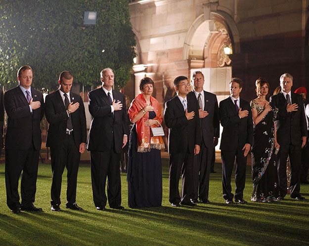 Members of the U.S. delegation stand during the playing of the U.S. national anthem during the state dinner for President Barack Obama and first lady Michelle Obama hosted by India's President Prathiba Patil and her husband Devisingh Ramsingh Shekhawat at Rashtrapati Bhavan in New Delhi, India, Monday, Nov. 8, 2010. From left are: Press Secretary Robert Gibbs, speech writer Jon Favreau, National Security Adviser Tom Donilon, senior adviser Valerie Jarrett, Commerce Secretary Gary Locke, Agriculture Secretary Tom Vilsack, Treasury Secretary Timothy Geithner, U.S. Ambassador to India Tim Roemer and wife Sally. (AP/Charles Dharapak)