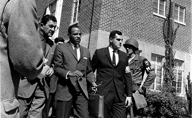 In this October 2, 1962, file photo, James Meredith, center with briefcase, is escorted to the University of Mississippi campus in Oxford. Escorting Meredith is Chief U.S. Marshal James McShane, left, and an unidentified marshal at right. (AP)