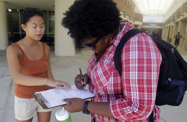Aubrey Marks, left, helps a University of Central Florida student to register to vote in Orlando, Florida. (AP/ =John Raoux)