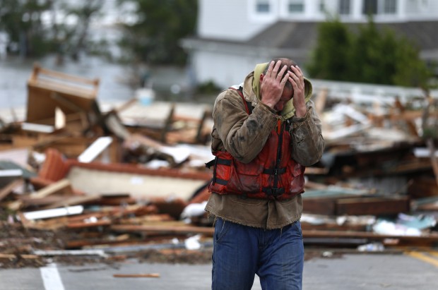 Brian Hajeski of Brick, New Jersey reacts after looking at debris of a home that washed up on to the Mantoloking Bridge the morning after Superstorm Sandy rolled through Mantoloking, New Jersey. (AP/ Julio Cortez)