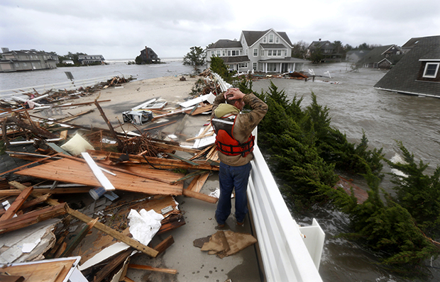 Brian Hajeski, 41, of Brick, New Jersey, reacts as he looks at debris of a home that washed up on to the Mantoloking Bridge the morning after Hurricane Sandy rolled through, Tuesday, October 30, 2012, in Mantoloking, New Jersey. (AP/Julio Cortez)