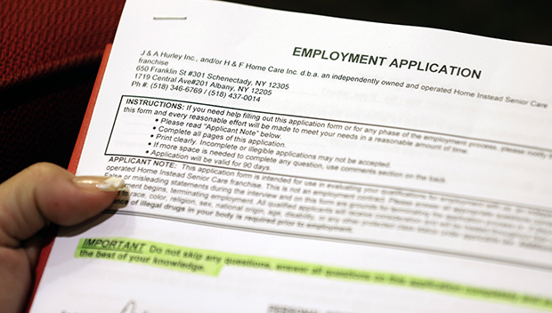 In this Thursday, October 25, 2012, photo, Carmen Nazario of Albany, New York, fills out an employment application during a job fair at the Marriott Hotel in Colonie, New York. (AP/Mike Groll)