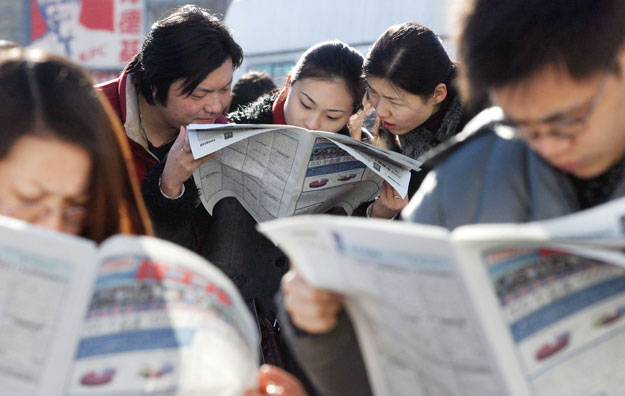 Job hunters read about employment opportunities at a job fair in Beijing. Several programs in China and around the world have been installed to help the unemployed find work. (AP/STR)