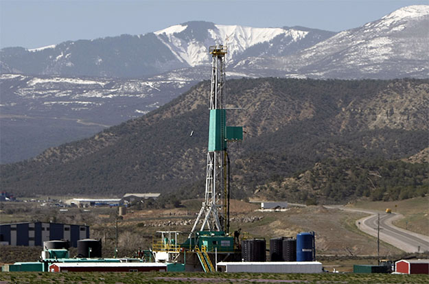 A natural gas well pad sits in front of the Roan Plateau near Rifle, Colorado. (AP/David Zalubowski)
