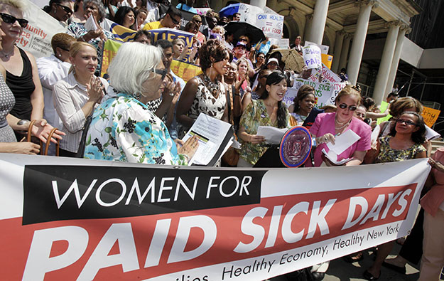 Ai-Jen Poo, center, Executive Director of the National Domestic Workers Alliance, reads her statement at a Women for Paid Sick Days rally on the steps of New York's City Hall on Wednesday, July 18, 2012. (AP/Richard Drew)