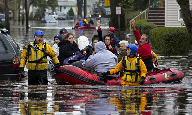 People, some waving to those on dry ground, are rescued by boat in Little Ferry, New Jersey, Tuesday, October 30, 2012, in the wake of Hurricane Sandy. (AP/Craig Ruttle)