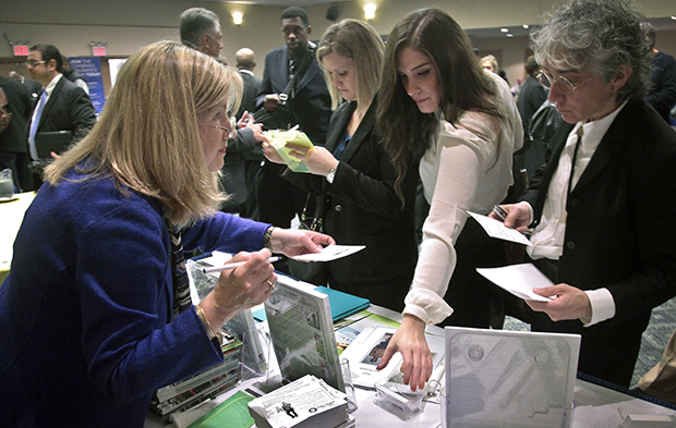 Patricia Mazza, left, meets job seekers during a National Career Fairs job fair in New York, Wednesday, October 24, 2012. (AP/Bebeto Matthews)