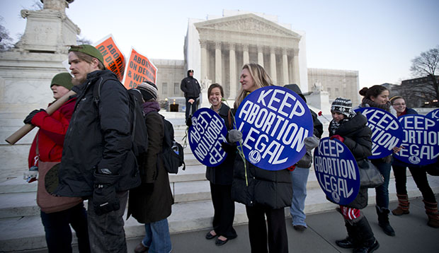 Bettina Hager, center, and Jeff Foster, left, join a candlelight vigil in front of the U.S. Supreme Court in Washington to commemorate the 40th anniversary of <em>Roe v. Wade</em>, the Supreme Court decision that legalized abortion, Tuesday, January 22, 2013. (AP/Manuel Balce Ceneta)