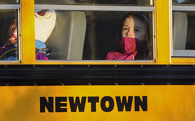 A girl sits on a Newtown bus leaving the new Sandy Hook Elementary School after the first day of classes in Monroe, Connecticut, Thursday, January 3, 2013. (AP/Jessica Hill)