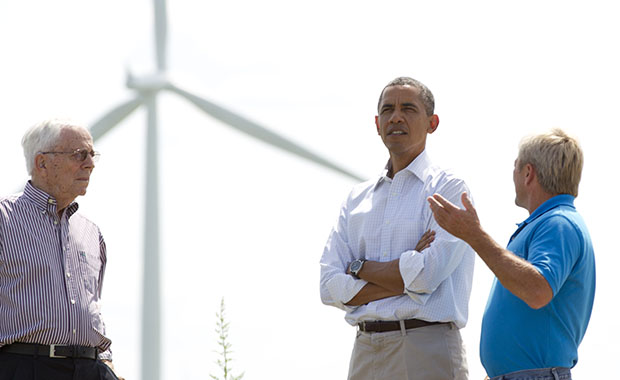 As wind turbines turn in the distance, President Barack Obama talks with Richard Heil, left, and Jeff Heil, on the Heil family farm, Tuesday, August 14, 2012, in Haverhill, Iowa, during a three-day campaign bus tour through Iowa. (AP/Carolyn Kaster)