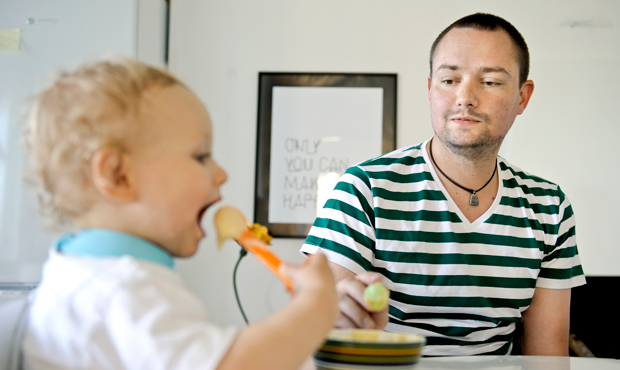 A father on workplace leave feeds his son in Stockholm, Sweden. The Family and Medical Leave Act was a good start for supporting workers and workplace fairness, but it needs to include more workers. (AP/ Niklas Larsson)