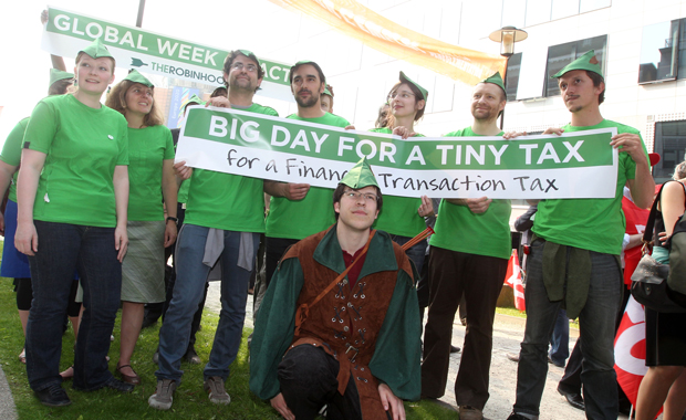 Campaigners and European trade unions dress as Robin Hood while calling on European Union leaders to go ahead with a financial transaction tax to mobilize money to help poor people hit by the economic crisis, in front of the European Council building in Brussels on May 23, 2012. (AP/ Yves Logghe)