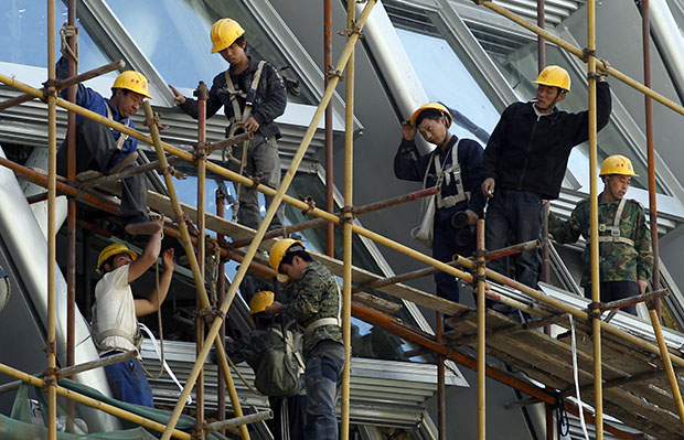 Workers stand on the scaffolding of a modern commercial building in Beijing, China, May 30, 2012. (AP/Ng Han Guan)