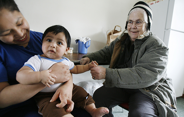 Nancy Sabin visits with a mother and child in Highgate, Vermont, Thursday, March 5, 2009. The Family and Medical Leave Act has certainly helped American workers, but many workers of color, who experience disproportionate rates of economic insecurity, are either ineligible or unable financially to take leave under the law. (AP/Toby Talbot)