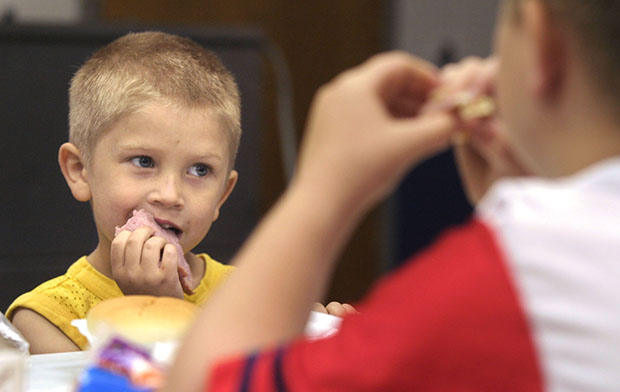 Christian Kellogg, 6, left, and his brother Anthony Kellogg, 9, eat lunch at King Elementary School in Des Moines, Iowa. (AP/J. Mark Kegans)