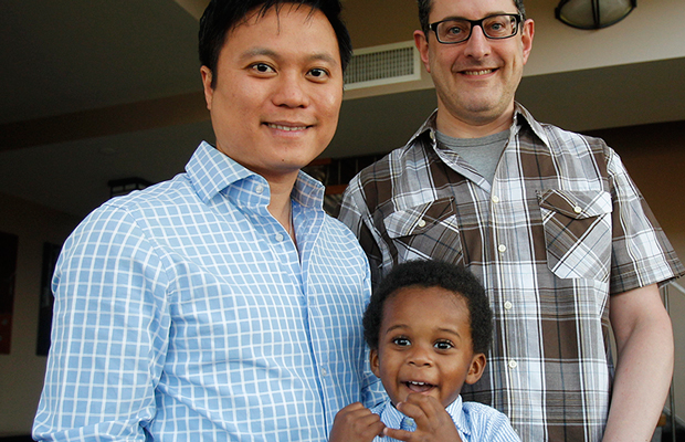 Jonathan Truong, left, his partner Ed Cowen, right, and their son Franklin Cowen Truong, 2, pose for a picture at their home in Brooklyn, New York. The Family and Medical Leave Act falls short of protecting gay and transgender workers and their families. (AP/ Frank Franklin II)