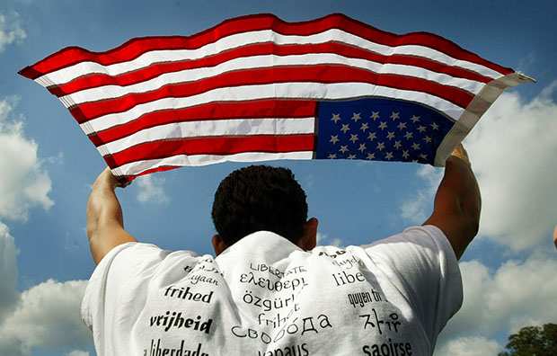 Juan Carlos Huezo Fuentes, who was born in El Salvador and now lives in San Jose, California, holds up a U.S. flag during a rally for immigrant rights in front of the Capitol Building in Washington, Thursday, October 2, 2003. (AP/Pablo Martinez Monsivais)