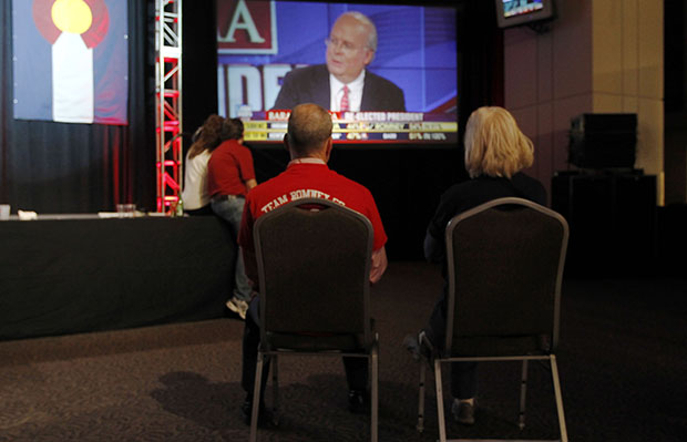 A couple sits on chairs in a near-empty room to watch Fox News commentator Karl Rove on a big-screen television during a Republican Party election night gathering in the club level of Sports Authority Field at Mile High in Denver, Colorado, on Tuesday, November 6, 2012. (AP/David Zalubowski)