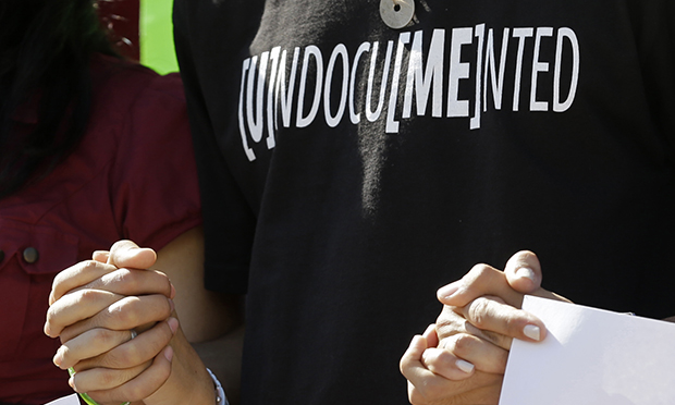 Los activistas de inmigración se toman de las manos frente a la Torre de la Libertad en el centro de Miami, el lunes 28 de enero de 2013.