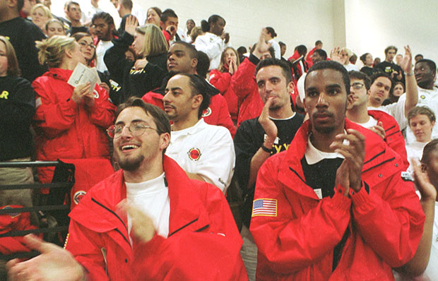 AmeriCorp volunteers Derek Haddad, left foreground, and Eddie Galan, right, both of Boston, applaud Friday, October 19, 2001, as they join some 1,000 new AmeriCorps members—who volunteer for one year to work in community service—during a rally to kick off their year of service. (AP/Patricia McDonnell)