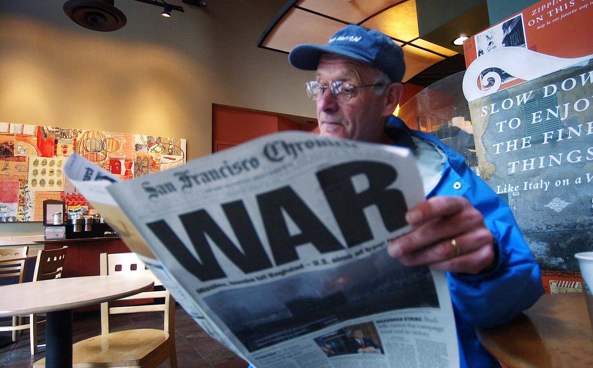Ray Jacques reads the San Francisco Chronicle's war special section inside a Starbucks coffee shop in San Francisco. Ten years after the invasion of Iraq, many members of the media who supported the war in 2003 are choosing not to comment. (AP/ Marco Jose Sanchez)