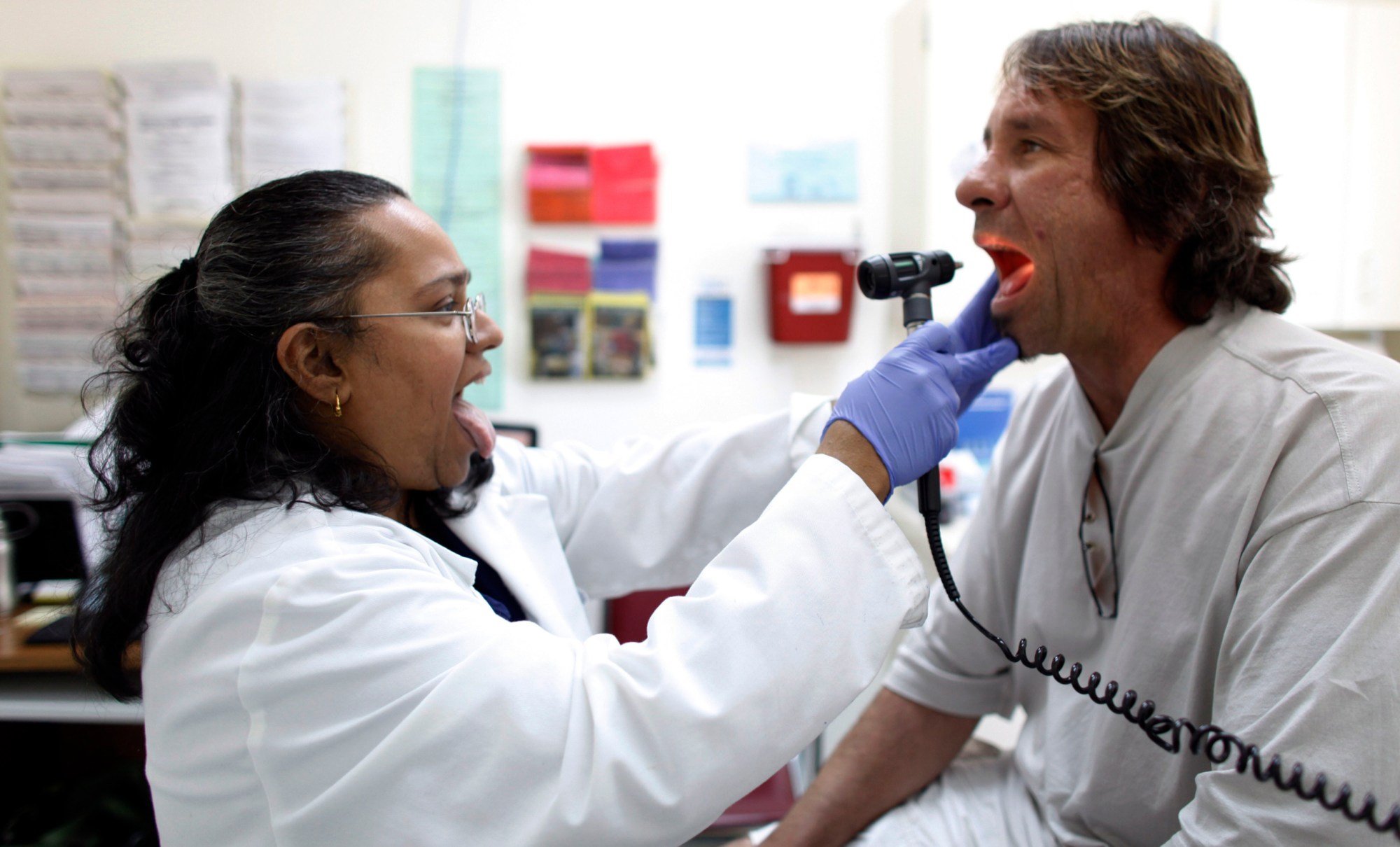 Dr. Hamsakumari Ramasubramaniam, left, examines patient Fabian Vasquez at Camillus Health Concern in Miami. Camillus is a private, non-profit organization that provides health care to the homeless, poor, and uninsured in Miami-Dade County.